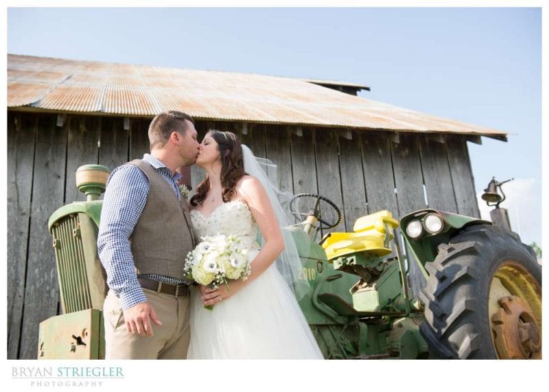 Amy and David's Wedding at The Barn at Hat Creek Ranch kissing in front of tractor