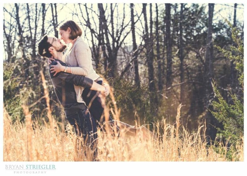 engagement photos in a field while picking her up