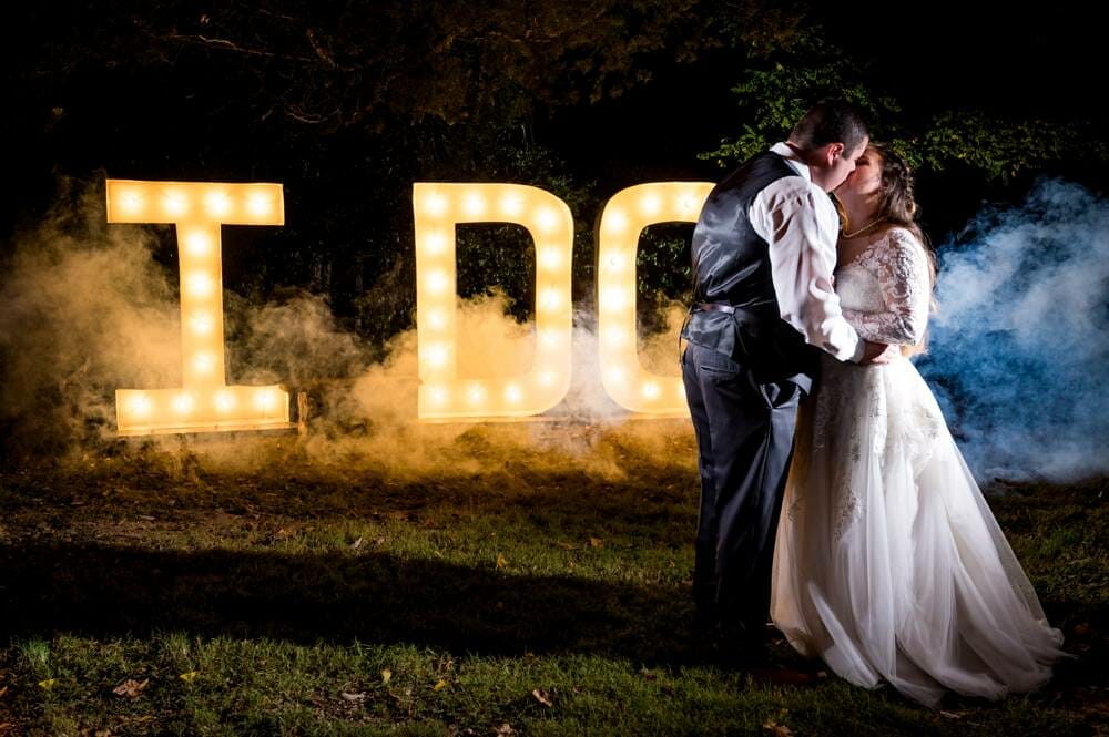 wedding photo at night with light up sign and smoke