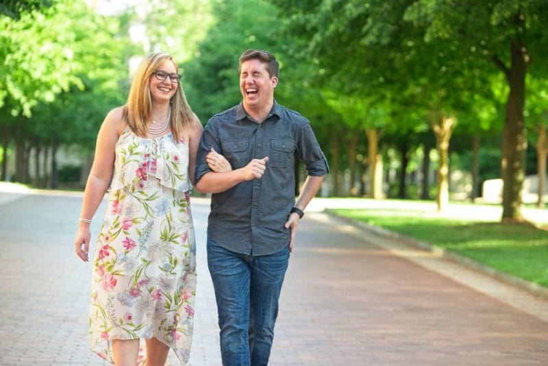 couple laughing and walking down U of A campus