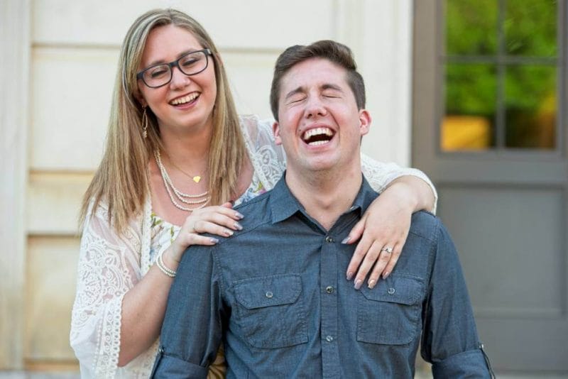 engagement photo with guy laughing and girl standing behind