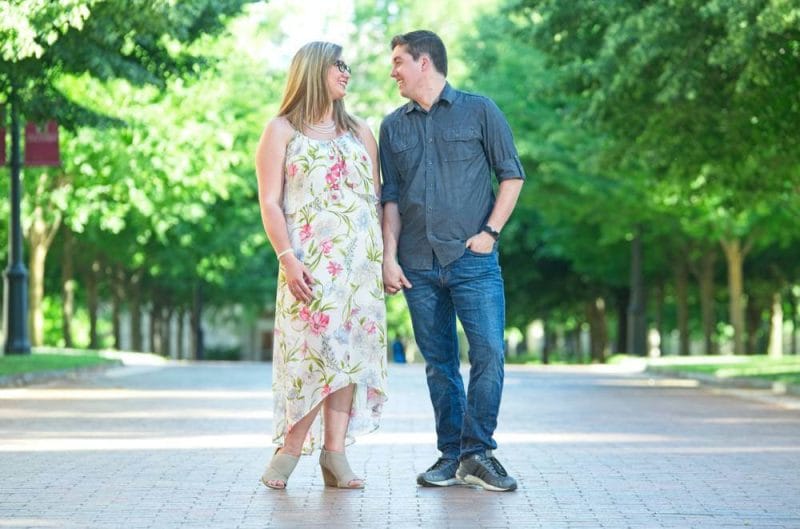 engaged couple smiling at each other at University of Arkansas