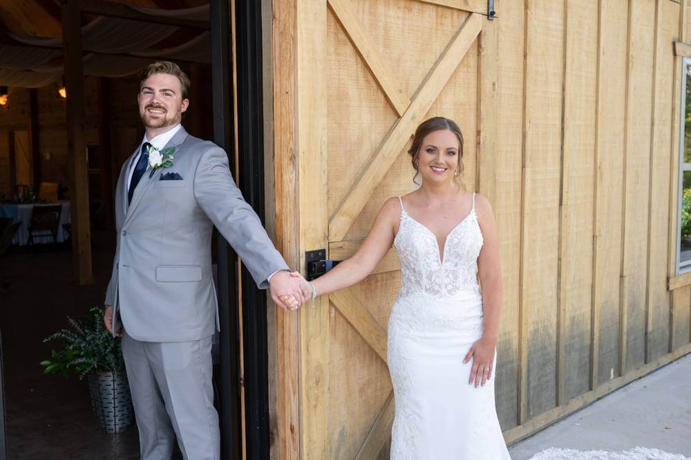 wedding couple holding hands around door