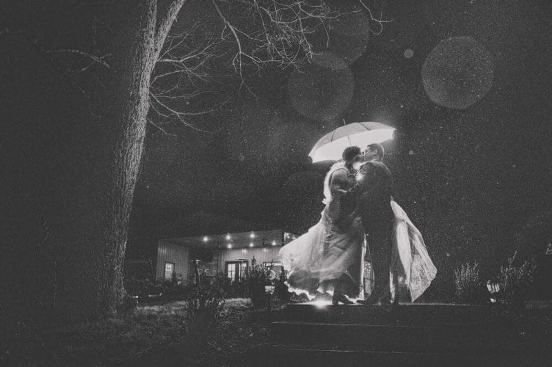 wedding couple in the rain with an umbrella black and white