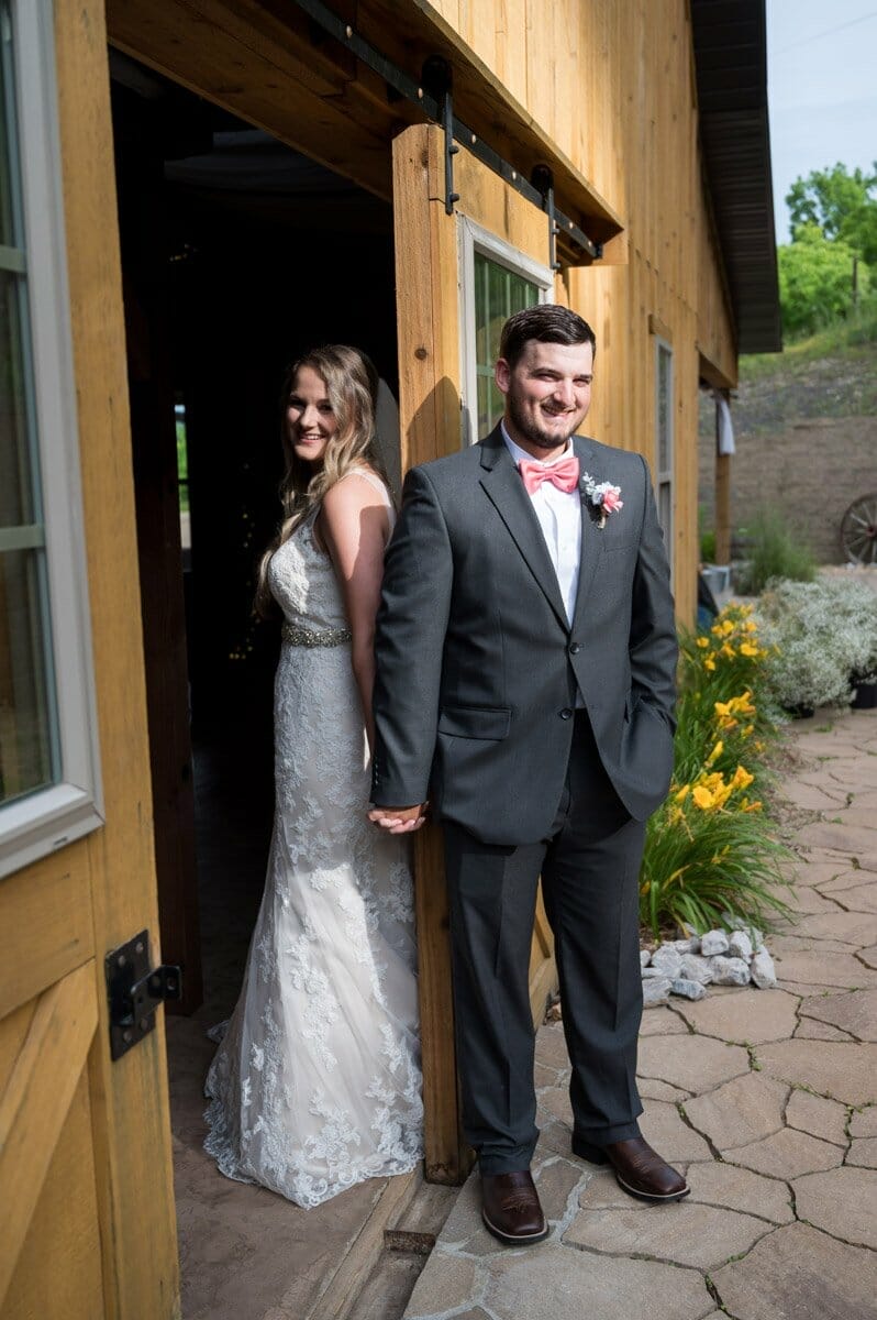bride and groom holding hands around a door