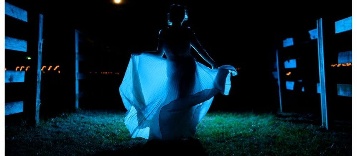 Dramatic photo of bride dancing at night with a full moon
